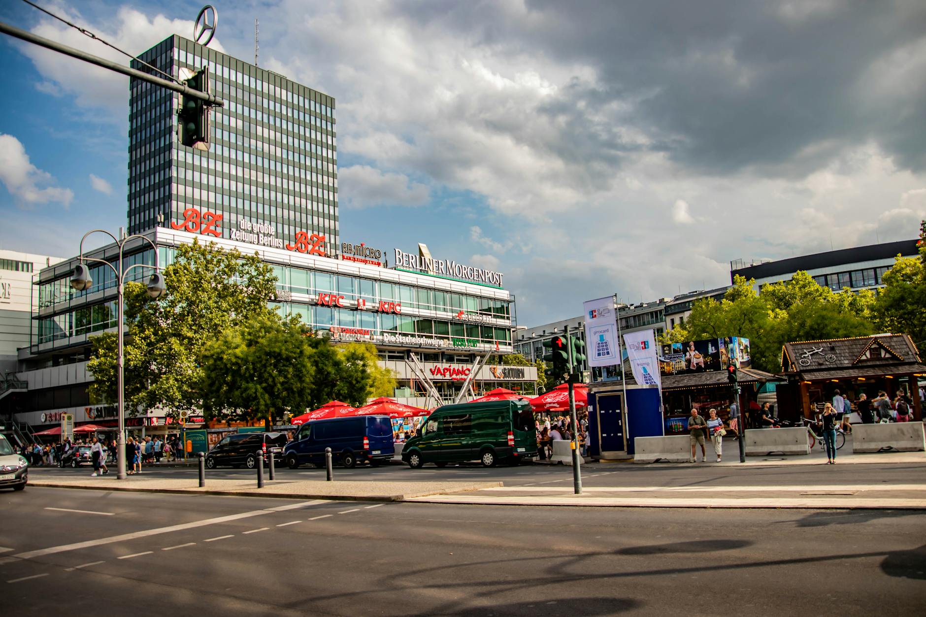 Bustling scene of Berlin's Europa-Center and Berliner Morgenpost under a cloudy sky.